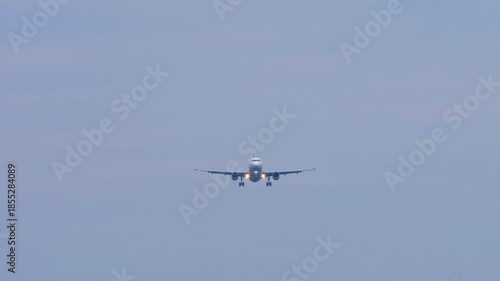 Jet airplane with an unrecognizable livery approaching landing, front view, long shot