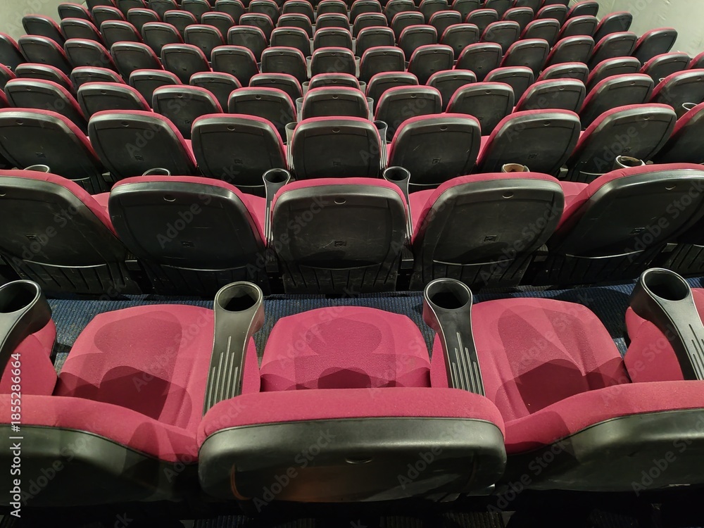 Fototapeta premium Rome, Italy - December 24, 2025, view of the empty stalls of a cinema, with particular attention to the rows of seats facing the big screen.