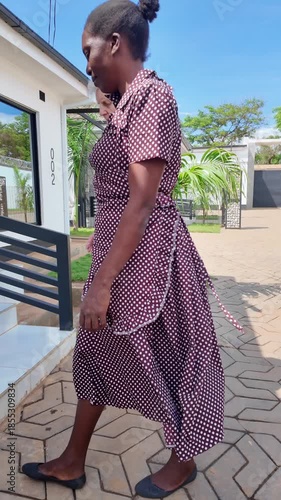 Lilongwe Malawi Africa, 01.12.2025. Video. African female  carer returning from a walk with an elderly Dementia sufferer  on holiday in Malawi Africa.