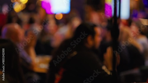 Faint image of gathering under illumination, Unclear group viewing energetic show in dim ambiance slow motion