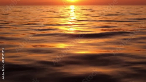 Golden Hour Ocean Reflections summer Overhead, wide shot of the ocean surface during a summer sunset. A serene wide shot of the ocean surface during a summer golden hour. The