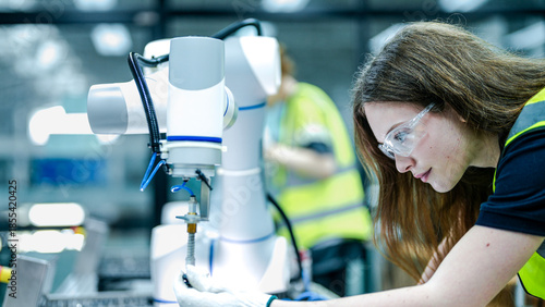Schilderij op canvas Two female robotics engineers in an R and D lab troubleshoot an artificial intelligence cobot