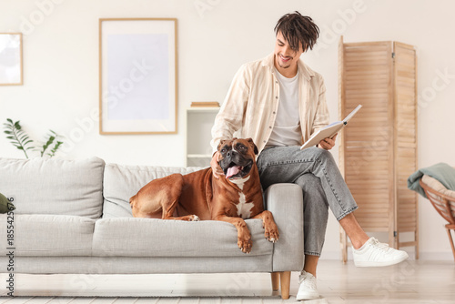 Young man with Boxer dog re...