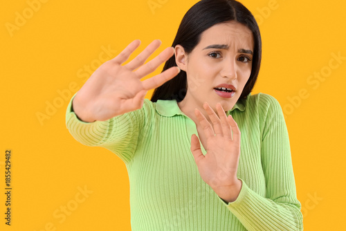 Scared young woman on yello...