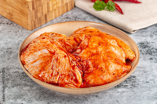 Tableau sur toile Raw chicken marinated thighs with skin