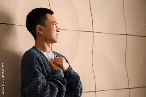 Sad young Asian man near be...