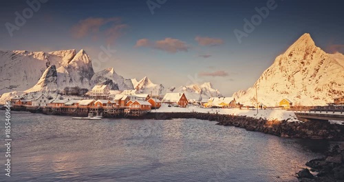 Lofoten islands beautiful nature sunset landscape in Norway and fishing town with scenic yellow rorbu houses of Sakrisoy, Reine