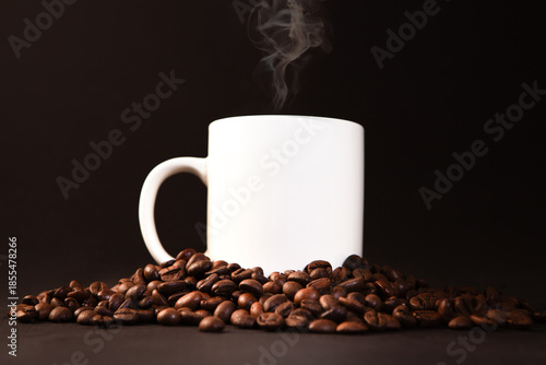 Coffee cup and coffee beans on a black background, close up