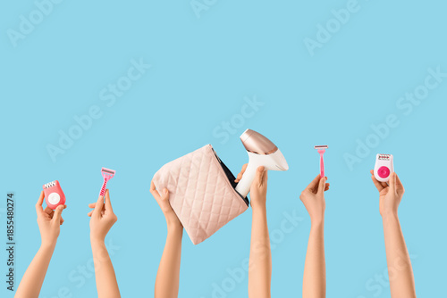 Canvastavla Many female hands with photoepilator, razors and epilators on blue background