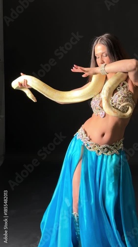 Exotic Belly Dancer Gracefully Interacting with Albino Python