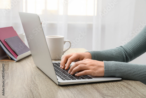 Wallpaper Mural Woman working with modern laptop and cup of coffee at table in office, closeup Torontodigital.ca
