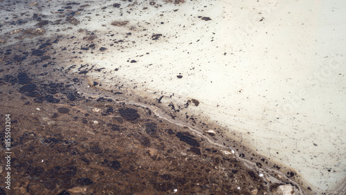 Dirty water contaminated with crude oil that drained into the public water supply, close-up at the water surface. Industrial problem and environmental impact issue, background.