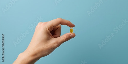 A Pill of wellness: A close-up view of a hand carefully holding a single vitamin capsule, illustrating health, wellness, and self-care in a concise manner.