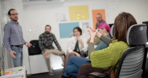 Business team discusses strategies in office setting with mixed group of men and women during afternoon meeting session