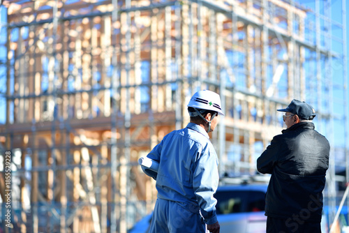 住宅建築の建て主と打ち合わせする工事監督