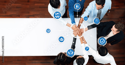Aerial view of diverse professionals engaged in active teamwork, demonstrating collaboration and management strategies to achieve common business goals at a conference table. Amity