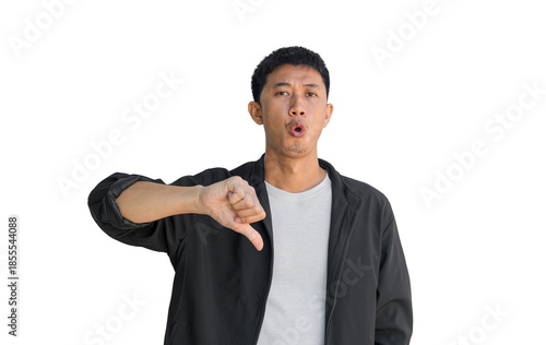 A young Asian man wearing black coat making a displeased gesture showing a thumbs down isolated on a white background. The concept of expressing dislike or opposing opinions