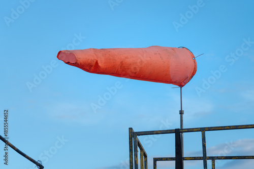 Konstfotografi An orange windsock on blue sky background