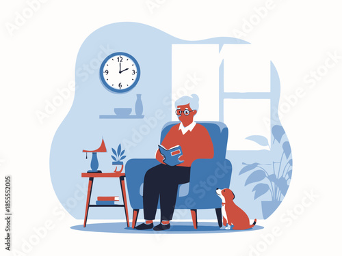 Senior man reading a book while sitting in a chair with a dog on a