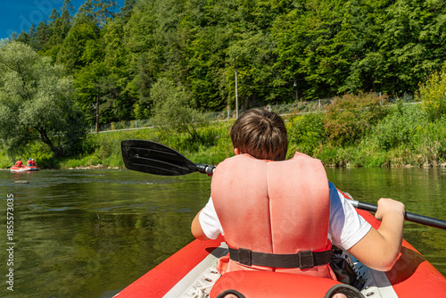 Kayaking on the Poprad River surrounded by green forest landscape