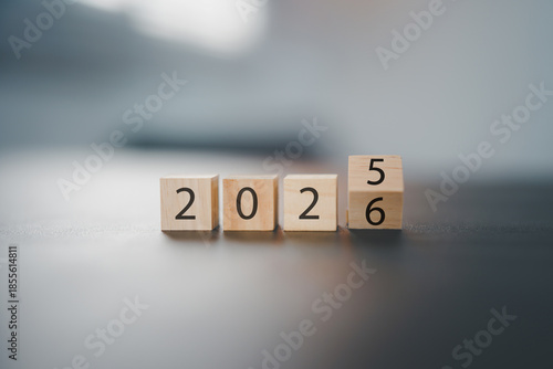 Transitioning from 2025 to 2026 with wooden blocks symbolizing target business for the upcoming year. This represents planning, investment, and innovation as ideas move from the end of 2025 new year