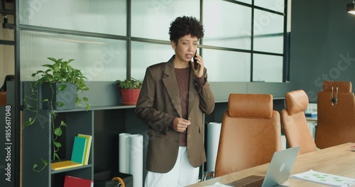 black consultant advising client on phone in bright office