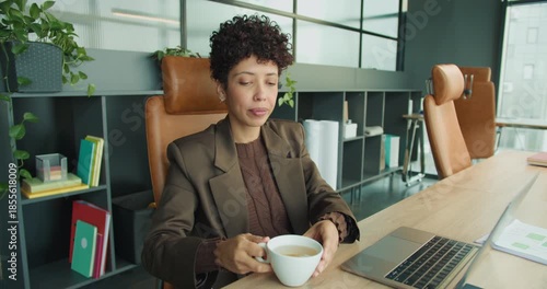 Person enjoying quick coffee and rest in modern workspace