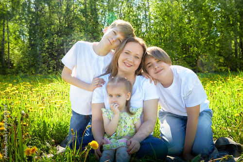 Family enjoys a sunny day outdoors surrounded by dandelions in a vibrant green meadow