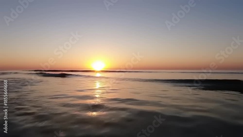 Golden Sunset Over Ocean Waves Reflecting Light on Water Surface.
