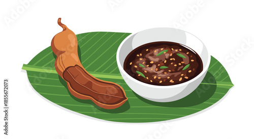 Fresh tamarind pod served with a bowl of dark spicy dipping sauce on a vibrant green banana leaf.