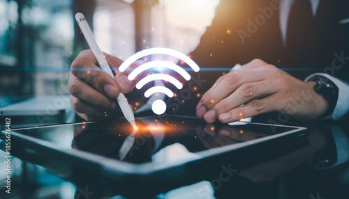 Business professional using tablet with glowing WiFi symbol overlay.