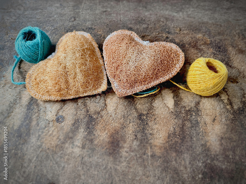 Twin Luffa heart shape,texture is coarse and fibrous.put on vintage wooden board,blurry light around