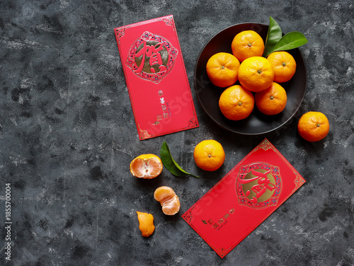 Top view of Mandarin oranges in a plate and two red envelopes for celebrating Chinese New Year