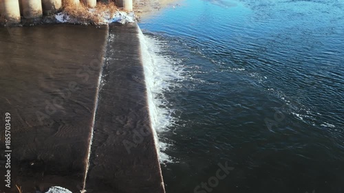 Aerial View Of Groyne Splitting Sea With Foamy Spray On One Side Symmetrical Concrete Structure Divides Calm And Turbulent Water, Bright Sunlight Highlights Textures, Suitable For Engineering,