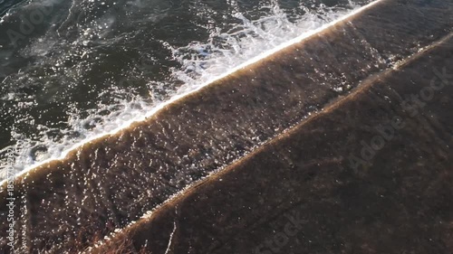 Diagonal Closeup Of Foam Line And Dark Wet Sand With Dynamic Ripples Intimate Texture Shot Highlights Granular Beach, Bursting Foam, Energetic Motion And Rhythmic Pattern For Abstract, Music