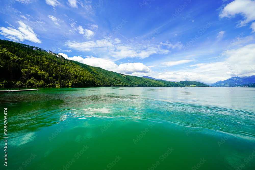 Obraz premium View of Lake Millstatt and the surrounding green landscape. Idyllic nature by the lake north of the Drava Valley near the town of Spittal an der Drau in Carinthia. 