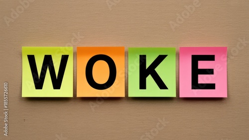 The word WOKE spelled out in bold black letters on vibrant colorful sticky notes displayed on a neut
