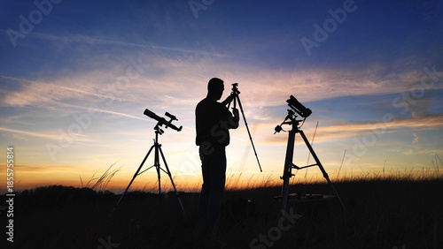Billede på lærred Amateur astro-photographer with a telescope and camera on a tripod photographing night sky with stars, planets, Moon and other celestial objects