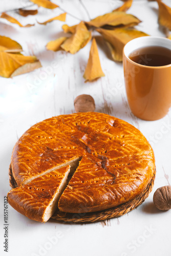 Homemade baked pie served on a shabby table with a cup of tea with autumn leaves and walnuts , autumn composition