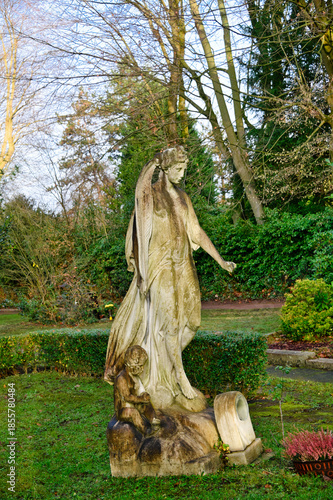 großer Engel mit Palmwedel auf einer Wiese für Urnenbestattungen alter Friedhof in Essen-Werden