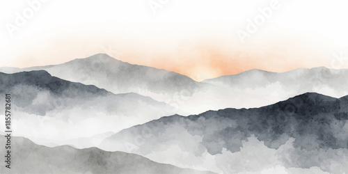 A breathtaking nature landscape view of misty clouds and haze rolling over high mountain peaks at a cloudy sunset where the blue sky meets a snow covered valley and morning fog