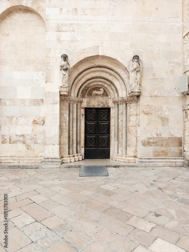 Romanesque portal of St. Anastasia Cathedral in Zadar, Croatia, featuring carved wooden door