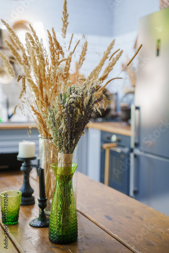 Dried flowers in vases on kitchen table with simple decor