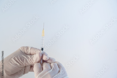 Gloved hands holding syringe preparing for vaccination