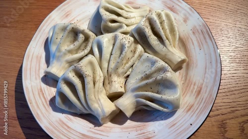 CloseUp Dumpling On Ceramic Plate, Textured Folds And Seasoning Visible, Pepper Specks And Soft Light Emphasize Pleats And Dough, Intimate Foodie Angle Ideal For Recipe Or Blog Content,