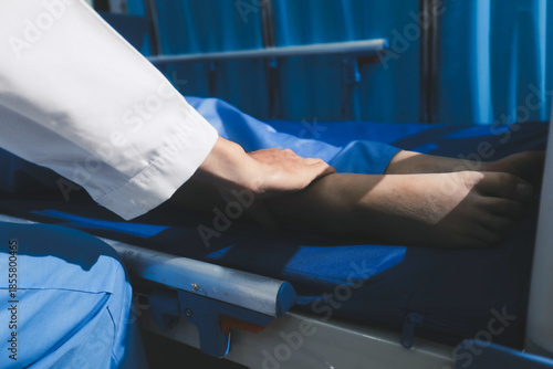 Asian male doctor examining foot of female patient sitting on bed in hospital room. Performing medical checkup. Diagnosing injury. Providing healthcare. Podiatry. Physical therapy. And rehabilitation