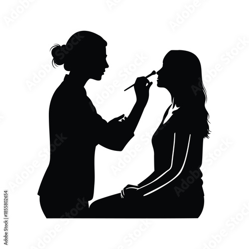 Makeup artist applying cosmetic to woman face