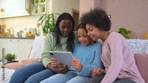 African american family with two daughters using a tablet at home
