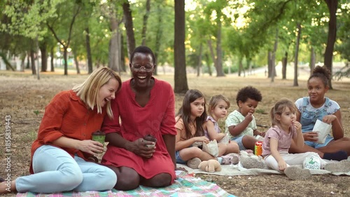 Multi-ethnic friends and children having a picnic in the park