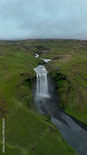 Explore the captivating beauty of Skogafoss Waterfall in Iceland. This stunning natural wonder flows powerfully amidst green hills, exuding a tranquil vibe that enchants visitors year-round.